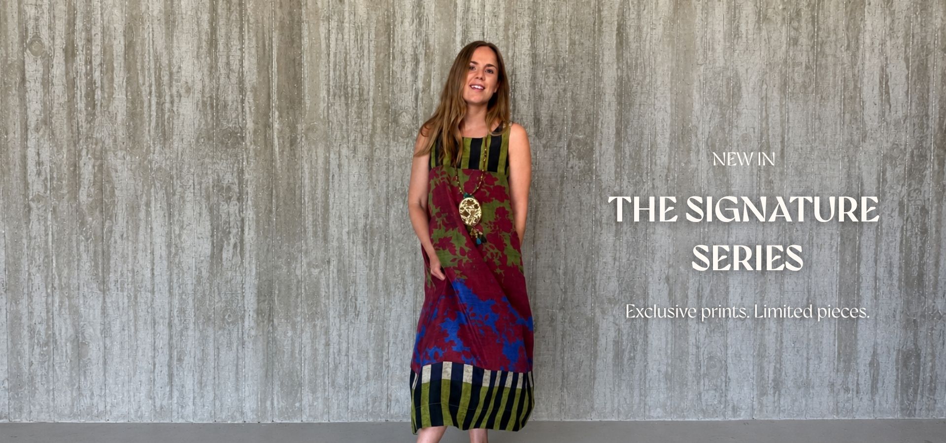 Woman wearing a colorful dress with 'The Signature Series' text on a textured wall backgroundslider_item_BKf4fw