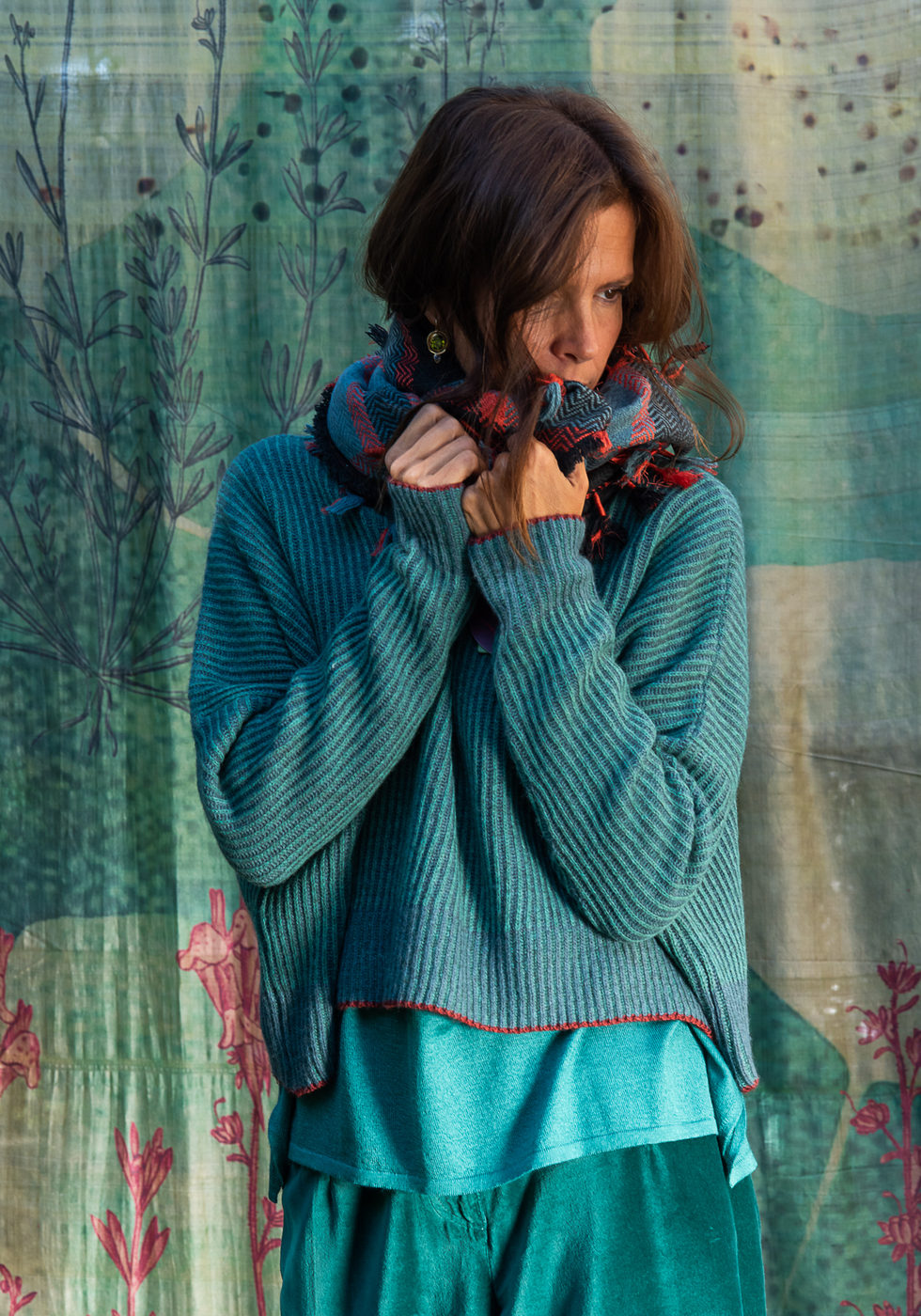 Turquoise jumper and skirt against the blue backdrop.