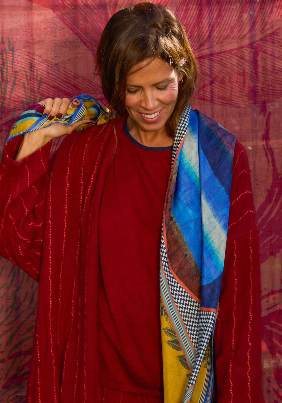 Red dress with a multicoloured scarf against the red backdrop.